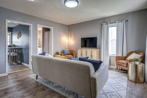 A living room with a sofa, armchairs, a TV, and a cabinet. - Highland Cottage near Downtown Park (Johnson City)