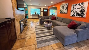 Una sala de estar moderna con un sofá modular, un televisor de pantalla plana montado en la pared y una chimenea.