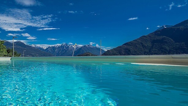A clear blue pool with mountains in the background.