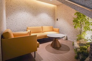 A modern interior with a sofa, armchair, and round table. - Urban Groove Hotel (Busan)