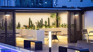 A rooftop lounge with a pool, seating areas, and various plants. - Urban Groove Hotel (Busan)