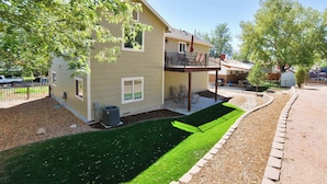 A two-story house with a balcony, a lawn, and a driveway. - Crestview Place! 2 Mins to UCCS, Patio, and BBQ (Colorado Springs)