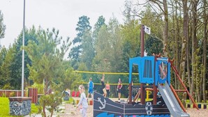 Ein Spielplatz mit Rutsche, Klettergerüsten und Sandkasten.