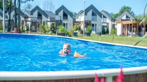 Ein Schwimmbad mit einer Person im Wasser, umgeben von Häusern.