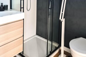 A modern bathroom with a glass shower enclosure, a white toilet, and a wooden vanity. - Luxury Houseboat for 2 People, by the sea (gmina Sianów)