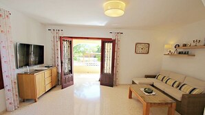 A living room with a sofa, coffee table, TV, and wooden cabinet. - Galicia - private pool villa in Benissa (Benissa)