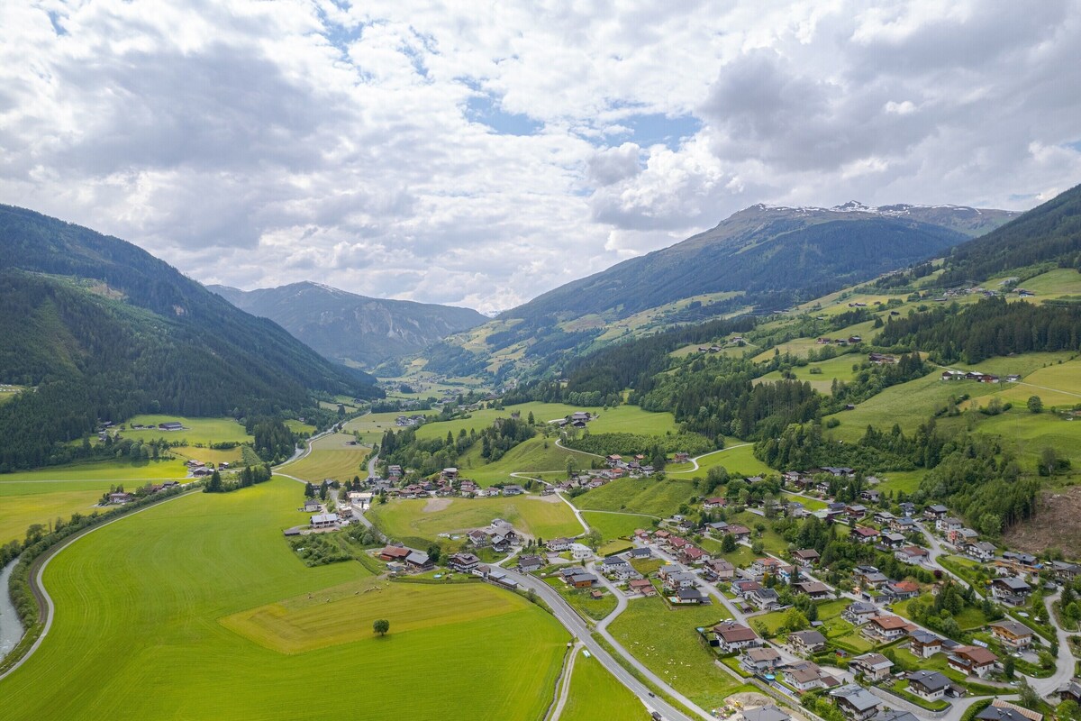 A rural village with houses, roads, and green fields.