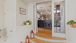 Une cuisine moderne avec un coin bar, un plancher en bois et des luminaires suspendus.