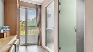 A modern bathroom with a glass shower door, a wooden bench, and a view of the outdoors. - 35.5 inn (Hengchun)