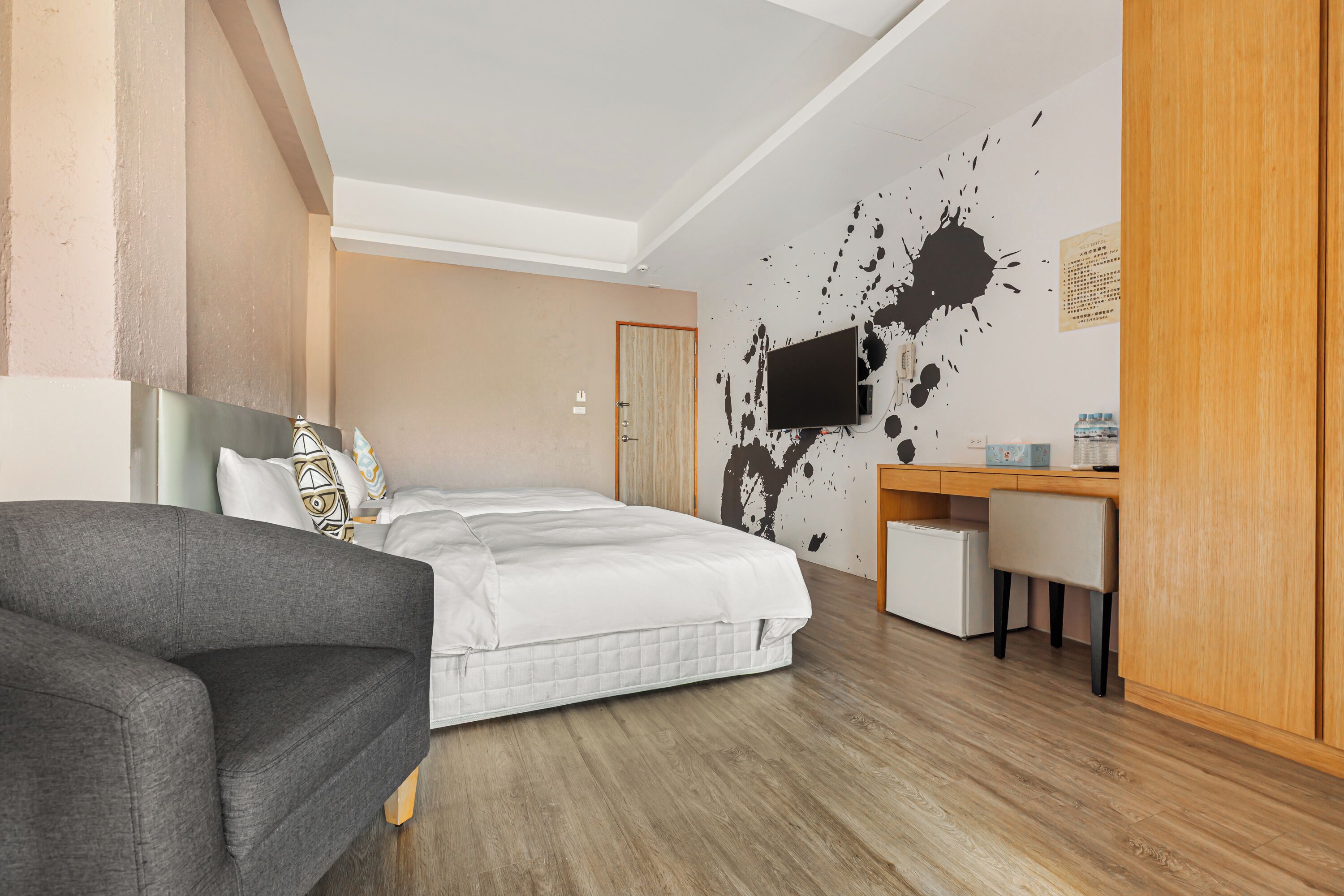 A modern bedroom with a bed, a desk, and a chair.