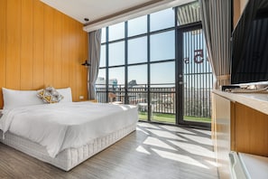 A modern hotel room with a large bed, wooden panel walls, a balcony with a view, and a kitchen area. - 35.5 inn (Hengchun)
