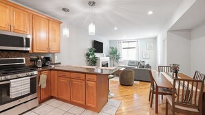 A modern kitchen with wooden cabinets, a stainless steel stove, and a large island.