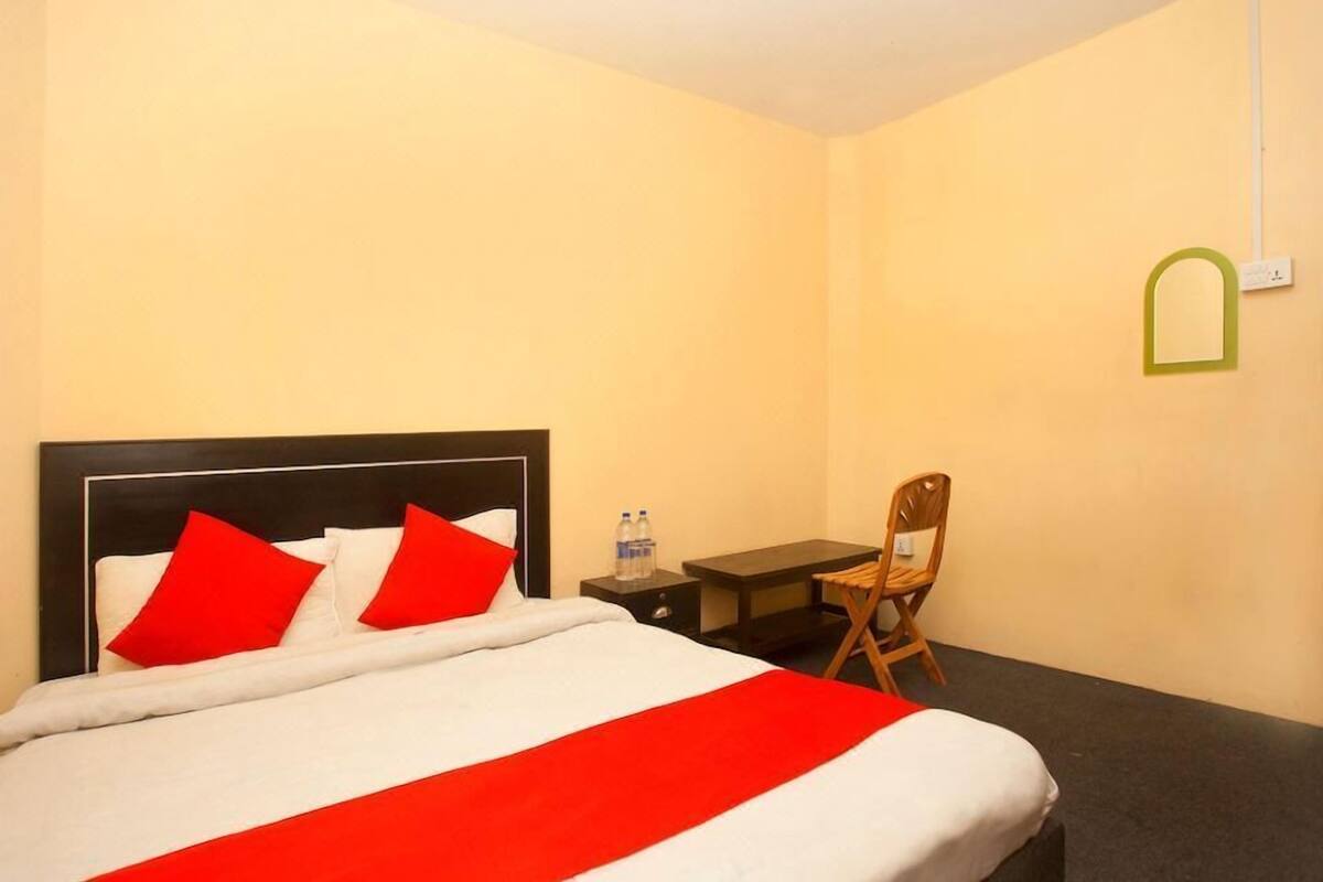 A hotel room with a bed, a desk, and a chair.
