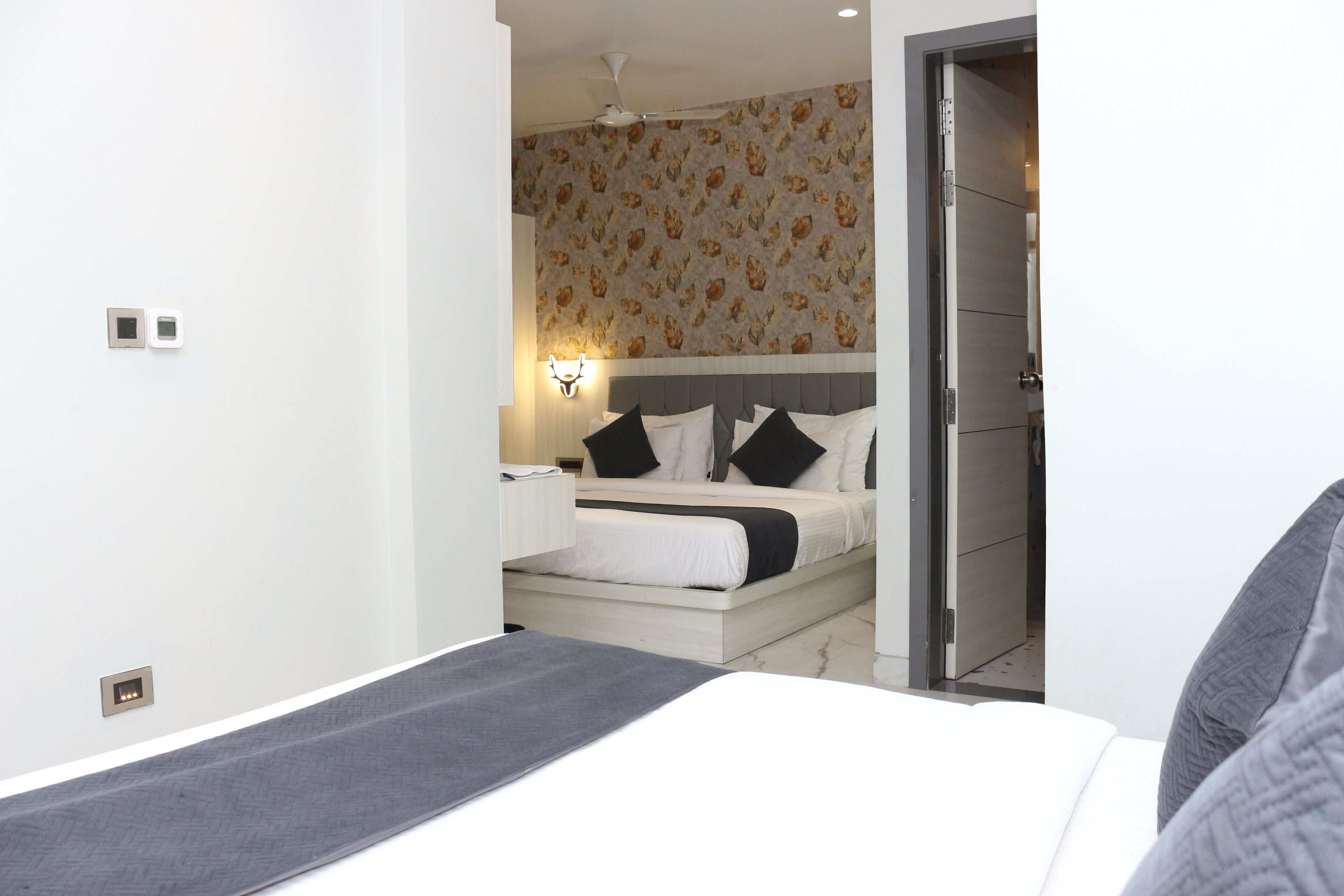 Una habitación de hotel moderna con cama, mesita de noche y velador.