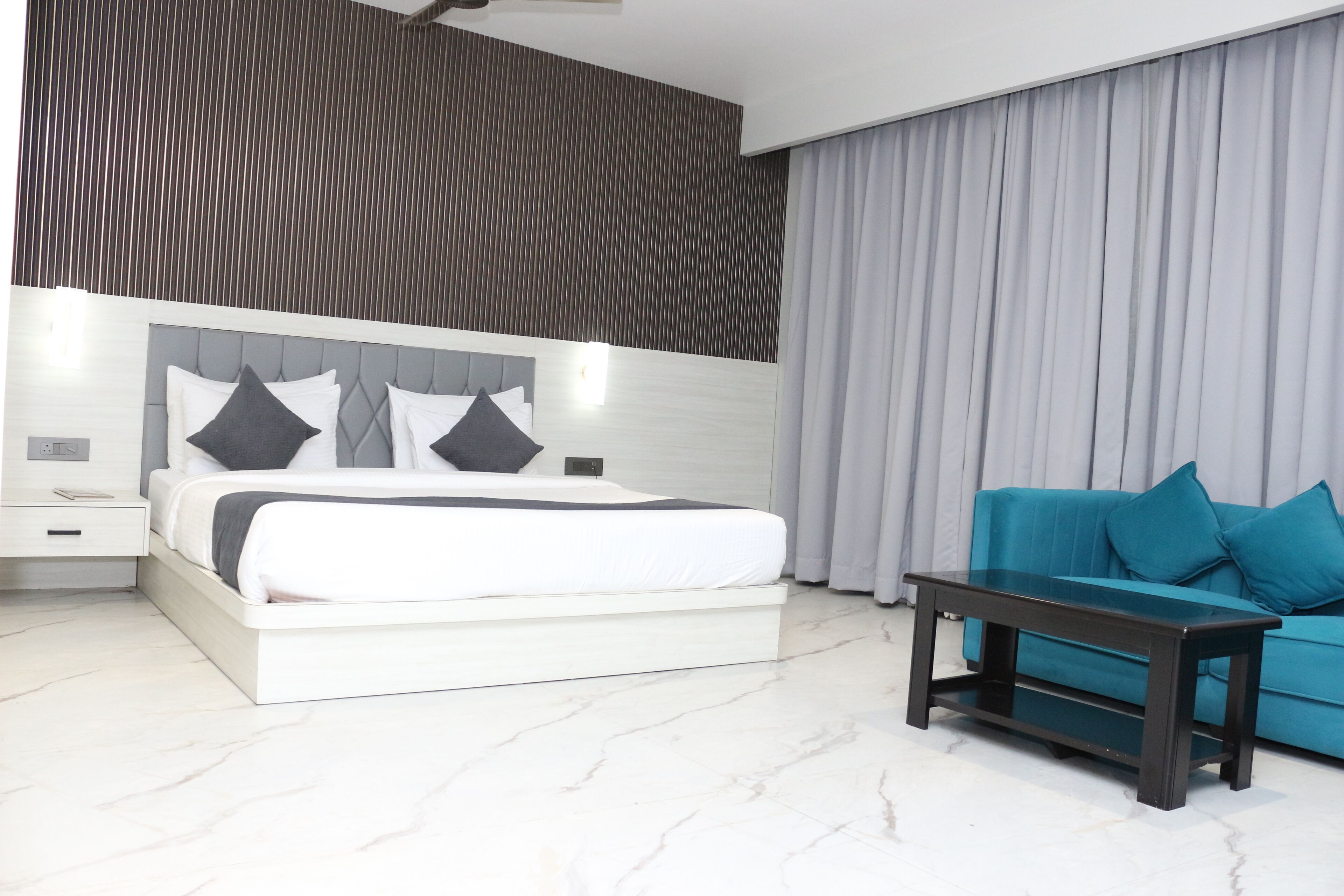 A modern bedroom with a bed, nightstand, and a dark wooden coffee table.