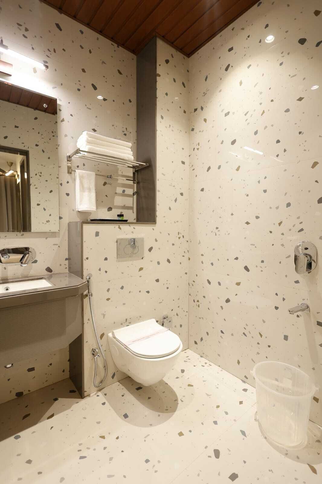 A bathroom with a white toilet, a sink, a mirror, and a towel rack.
