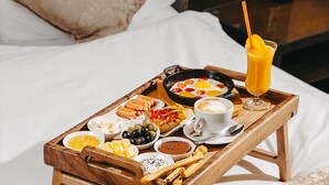 A wooden tray with breakfast items on a bed. - Pure Boutique Hotel  (Baku)