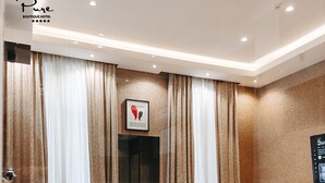 A modern hotel room with a large bed, a desk, and a bathroom with a bathtub. - Pure Boutique Hotel  (Baku)