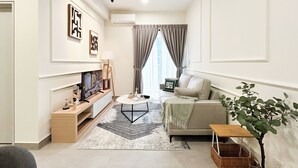 A modern living room with a sofa, a coffee table, a TV, and a ceiling fan. - Sunsuria Forum by Manhattan Group  (Shah Alam)