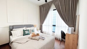 A neatly arranged hotel room with a bed, a desk, and a window with curtains. - Sunsuria Forum by Manhattan Group  (Shah Alam)