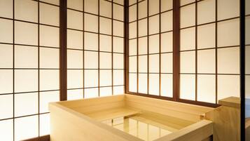 A traditional Japanese room with tatami flooring, a wooden washbasin, and shoji screens.