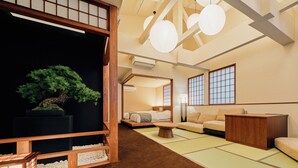 A traditional Japanese-style room with tatami flooring, a low wooden bed, a tatami mat table, and a bonsai tree. - KONJAKUSO Osaka Tempozan KANOH  SHOHAKU (Osaka)
