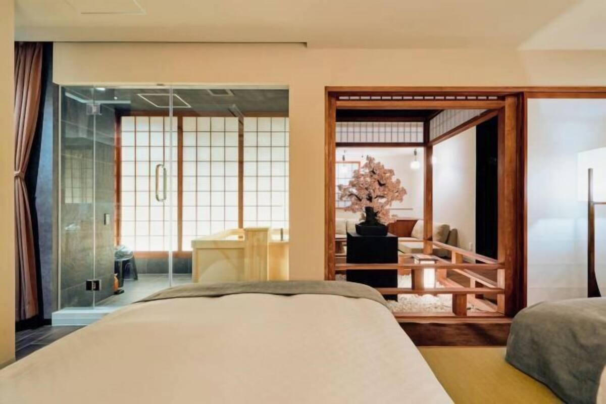 Une chambre d’hôtel avec un lit, un bureau et une porte coulissante de style japonais traditionnel.