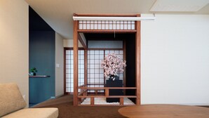 A traditional Japanese room with tatami flooring, a low wooden table, and a sliding door with a floral arrangement. - KONJAKUSO Osaka Tempozan KANOH  SHOHAKU (Osaka)