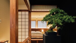 A traditional Japanese-style room with tatami flooring, a low wooden bed, a bonsai tree, and a shoji screen. - KONJAKUSO Osaka Tempozan KANOH  SHOHAKU (Osaka)