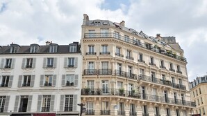 Ein mehrstöckiges Gebäude mit Balkonen und Fenstern, typisch für europäische Architektur.