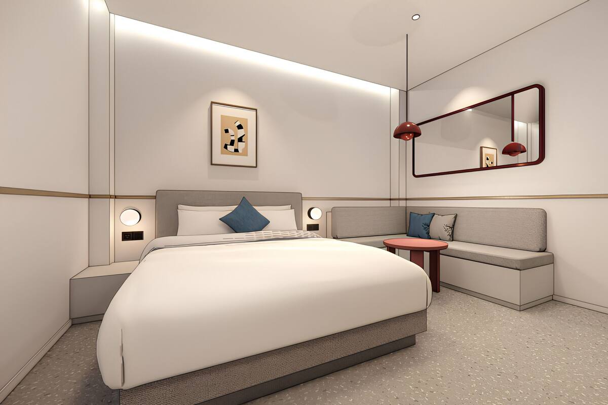 Een moderne hotelkamer met een groot bed, een slaapbank, een klein tafeltje en een spiegel.