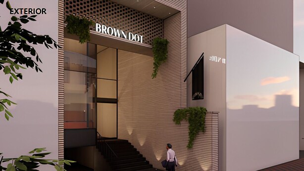 Un bâtiment moderne avec une enseigne indiquant « BROWN DOT » et un escalier menant à l’entrée.