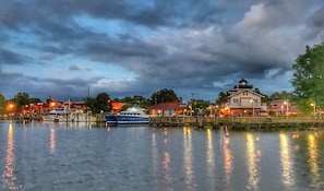 A waterfront property with a dock, a boat, and a building with a lighthouse.