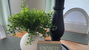 A wooden table with a potted plant, a candle, and a card on a tray. - OldCharm Spacious 2bdrmhouse in perfect location in Burley with WiFi,Central Air (Burley)