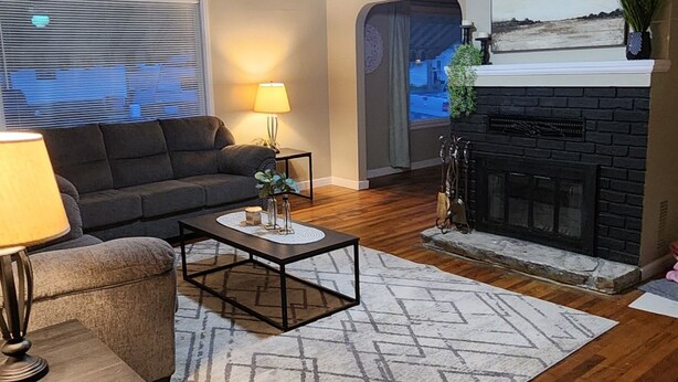 A living room with a fireplace, a sofa, a coffee table, and a lamp. - OldCharm Spacious 2bdrmhouse in perfect location in Burley with WiFi,Central Air (Burley)