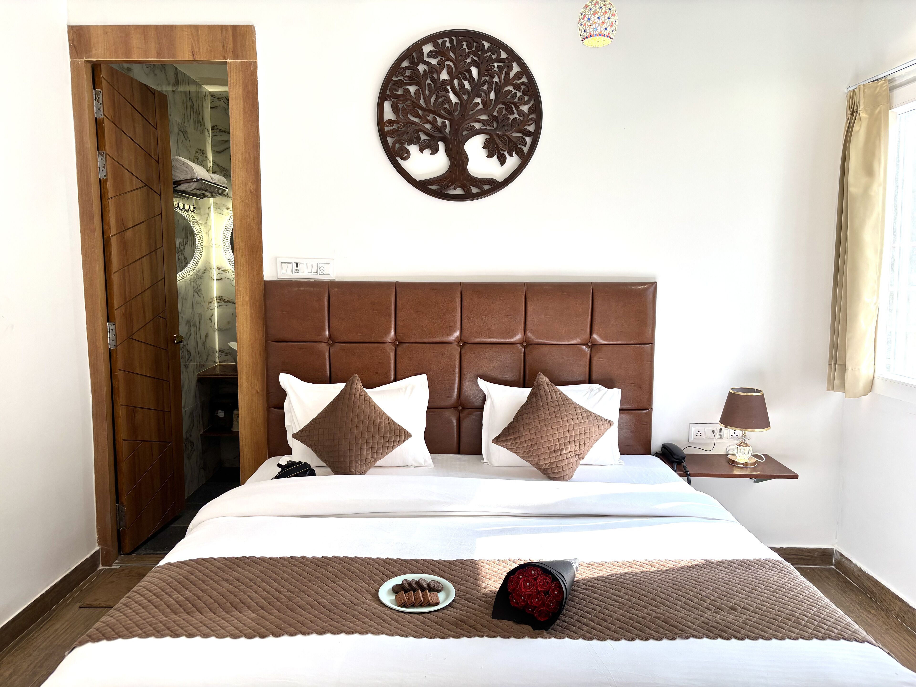 Una habitación de hotel con cama, mesita de noche, una obra de arte en la pared y una puerta.