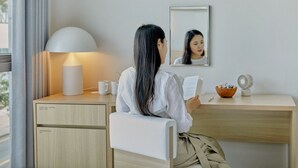 A hotel room with a desk, a lamp, a mirror, a fan, and a window with curtains. - Anook Hotel Sejong (Sejong)