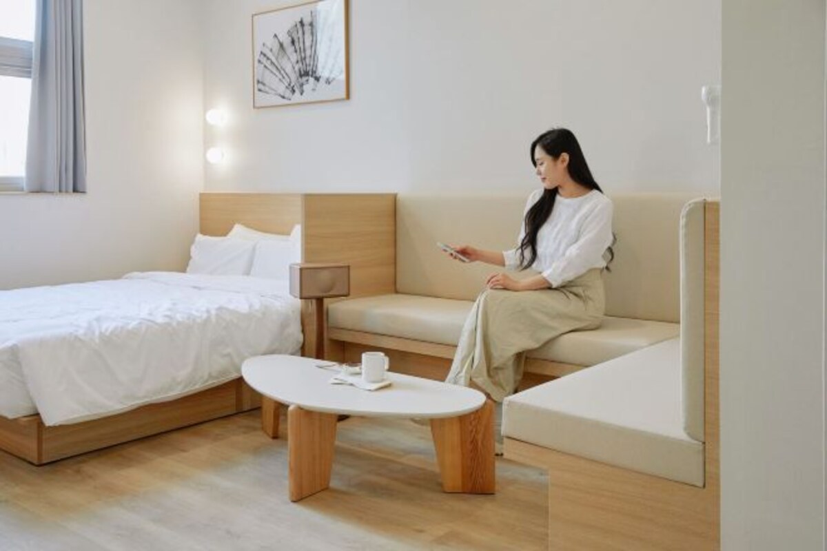Une chambre d’hôtel moderne équipée d’un lit, d’un canapé, d’une table basse et d’une lampe de chevet.