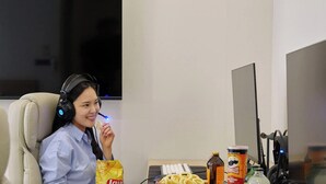 A person in a hotel room with a desk, headphones, snacks, and a computer setup. - Anook Hotel Sejong (Sejong)