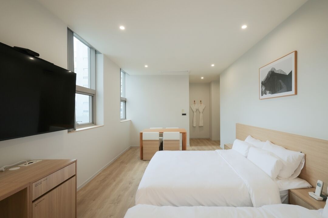 Een moderne hotelkamer met een groot bed, een bureau en een televisie.