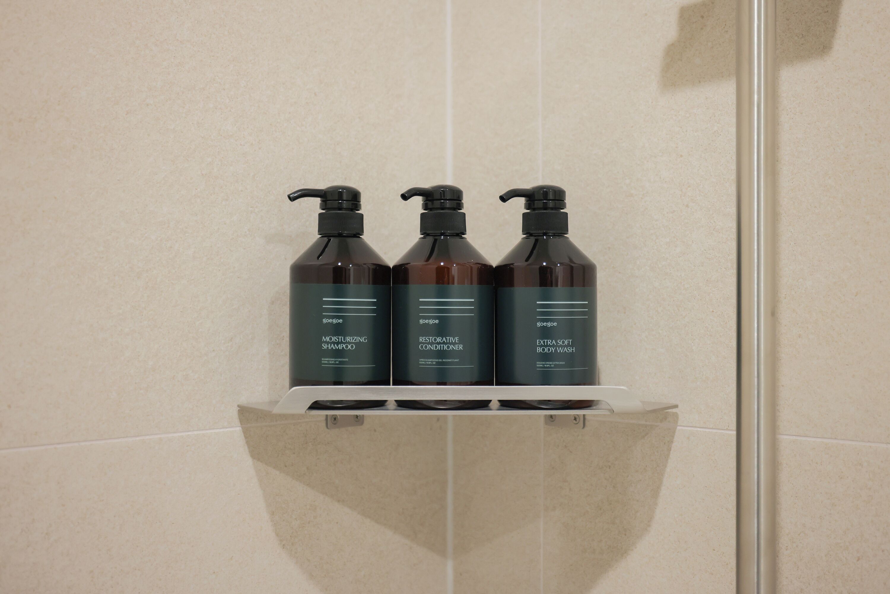 Three bottles of shampoo on a shelf.