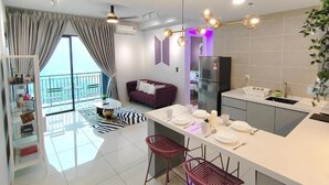 A modern apartment with a kitchen, dining area, and a balcony with a view. - IPOH Sunway Onsen Suites by uBook (Ipoh)