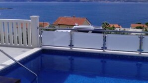 A swimming pool with a view of the sea and distant hills. - Apartments Cihorich (Dugi Rat)