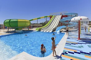 A water park with a pool, slides, and water play structures.