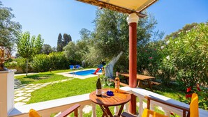 A patio with a pool, outdoor furniture, and a garden. - Villa Memi in Spartia (Kefalonia)
