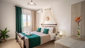 Un dormitorio con cama, mesita de noche, lámpara y una planta en maceta.