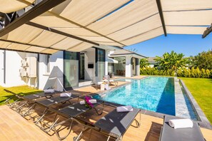 A modern outdoor pool area with sun loungers and a covered seating area. - Villa White Cloud in Dalyan (Ortaca)