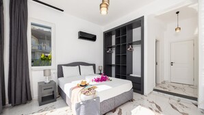 A modern bedroom with a bed, bedside tables, a wardrobe, and a window with curtains. - Villa White Cloud in Dalyan (Ortaca)