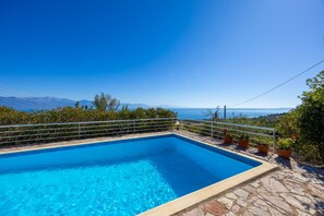 A rectangular swimming pool with clear blue water, surrounded by stone steps and metal railings. - Villa Thalia in Pilos Nestor (Messini)