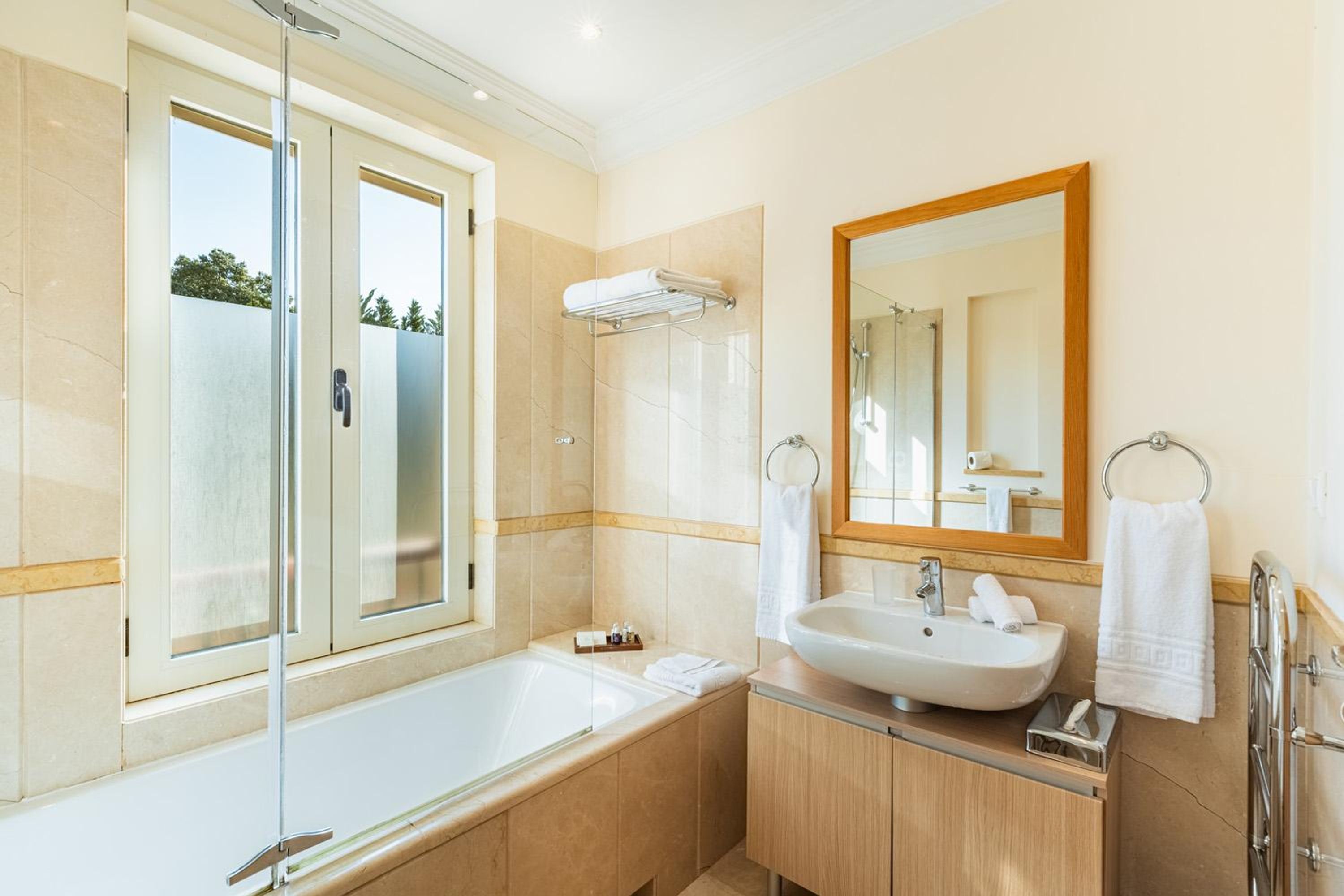 Une salle de bain moderne avec une douche à parois de verre, un grand lavabo et un miroir.